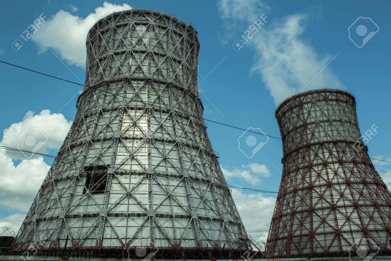 View of the power plant and cooling towers. The smoke goes out from a cooling tower of an operating power station. Cooling towers of a thermoelectric power station are reflected in a technical reservoir. Concept of ecology, environmental protection. - 148538669 View of the power plant and cooling towers. The smoke goes out from a cooling tower of an operating power station. Cooling towers of a thermoelectric power station are reflected in a technical reservoir. Concept of ecology, environmental protection. - 148538669