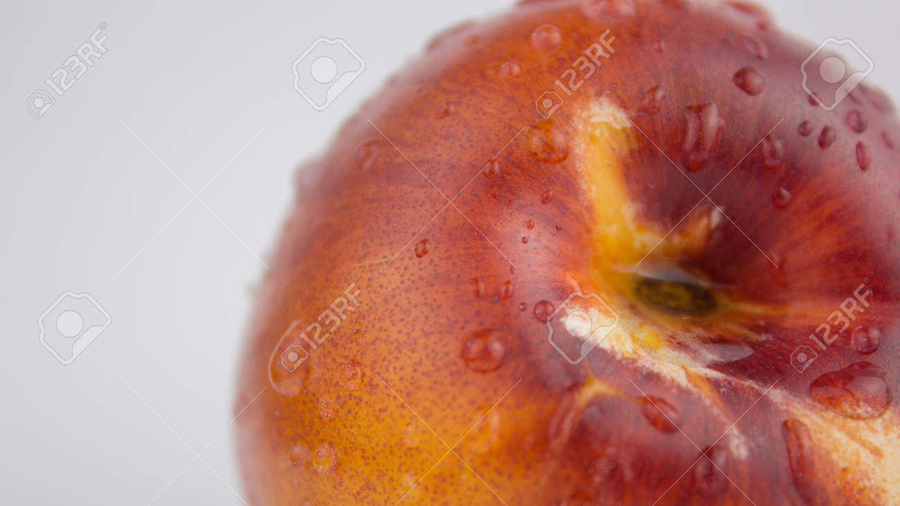 A drop of water flows down a fresh juicy peach. Fresh organic Peach covered with dew drops. Fresh juicy peaches on a white plate. - 152883813 A drop of water flows down a fresh juicy peach. Fresh organic Peach covered with dew drops. Fresh juicy peaches on a white plate. - 152883813
