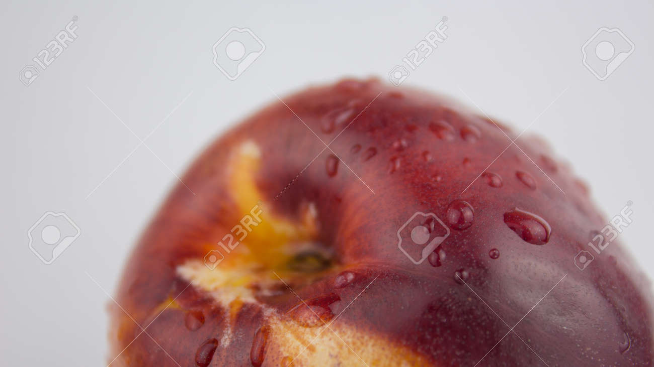 A drop of water flows down a fresh juicy peach. Fresh organic Peach covered with dew drops. Fresh juicy peaches on a white plate. - 152883460 A drop of water flows down a fresh juicy peach. Fresh organic Peach covered with dew drops. Fresh juicy peaches on a white plate. - 152883460