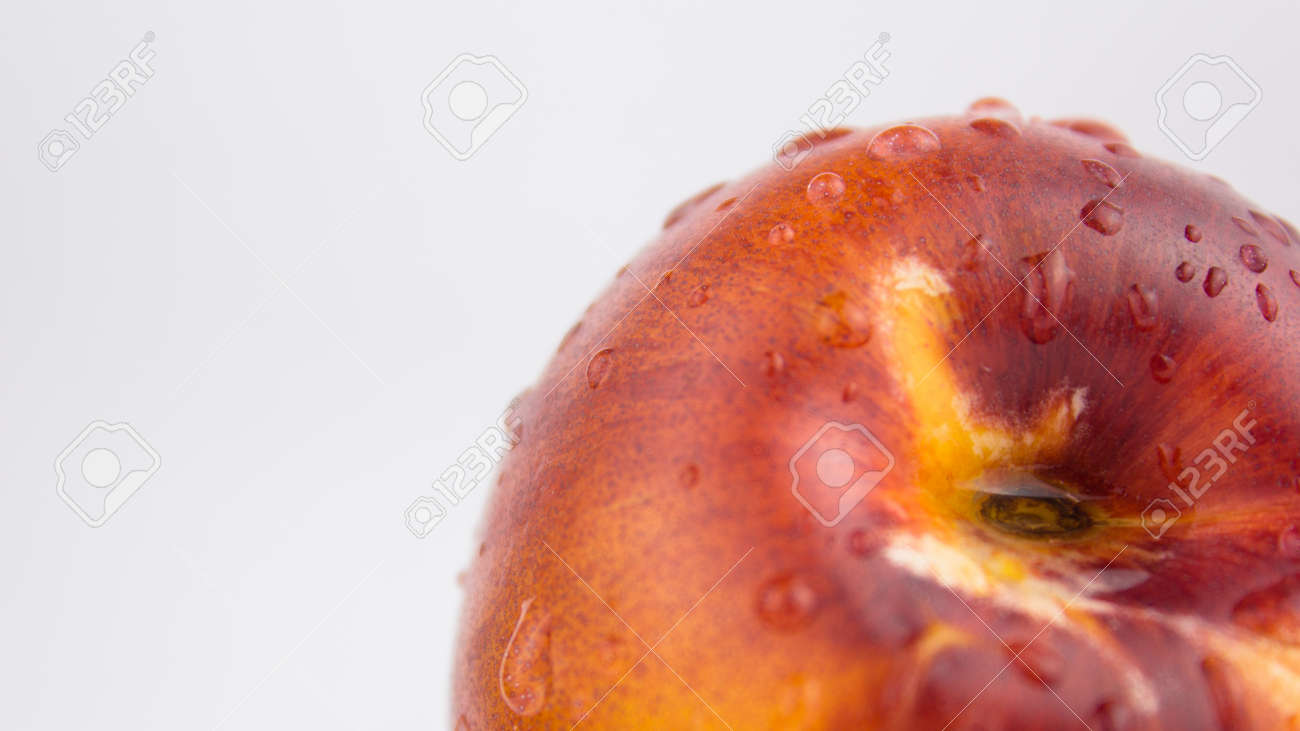 A drop of water flows down a fresh juicy peach. Fresh organic Peach covered with dew drops. Fresh juicy peaches on a white plate. - 152883672 A drop of water flows down a fresh juicy peach. Fresh organic Peach covered with dew drops. Fresh juicy peaches on a white plate. - 152883672