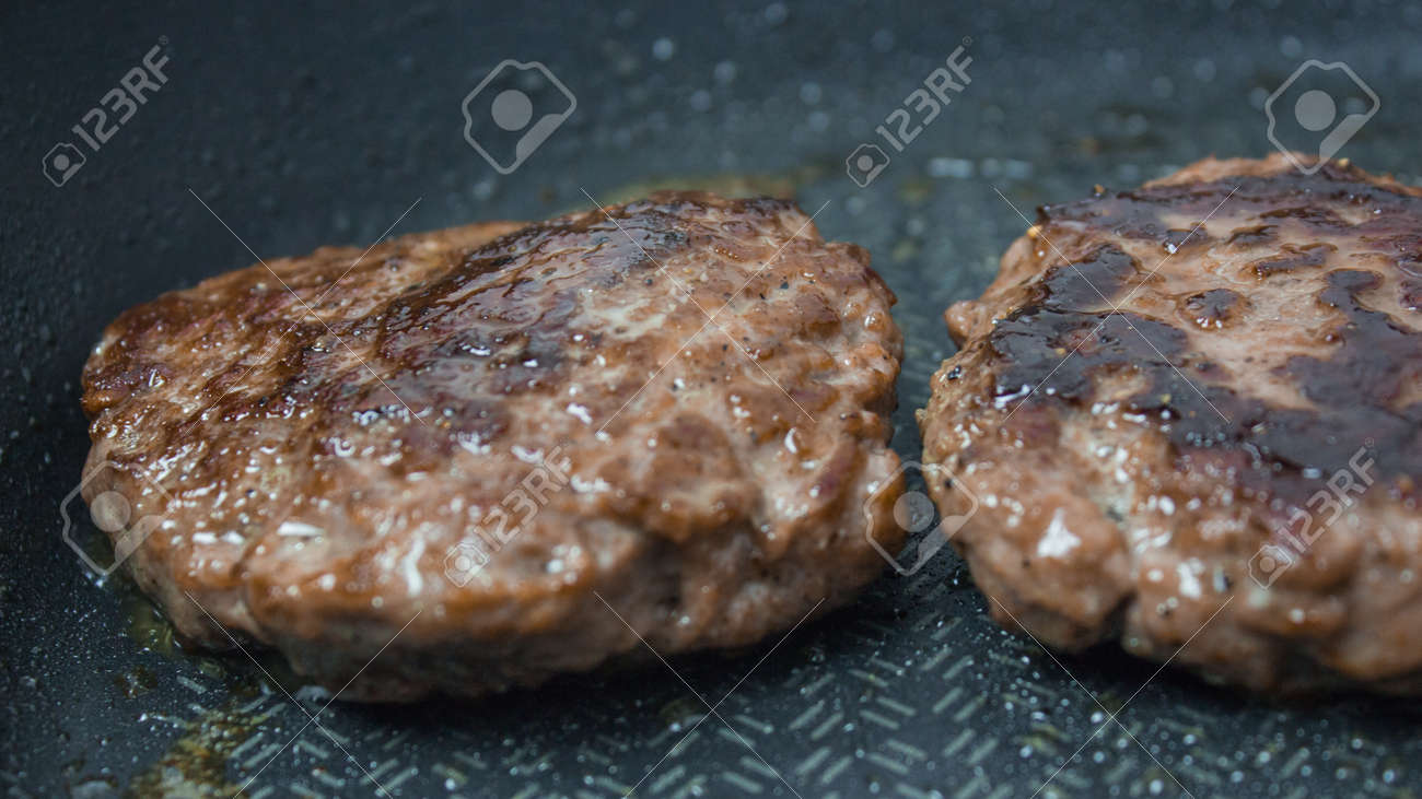 A chef puts beef patties on the grill. A juicy beef cutlet, fried in a pan. Close-up of beef cutlet for a burger on the grill. - 152883722 A chef puts beef patties on the grill. A juicy beef cutlet, fried in a pan. Close-up of beef cutlet for a burger on the grill. - 152883722