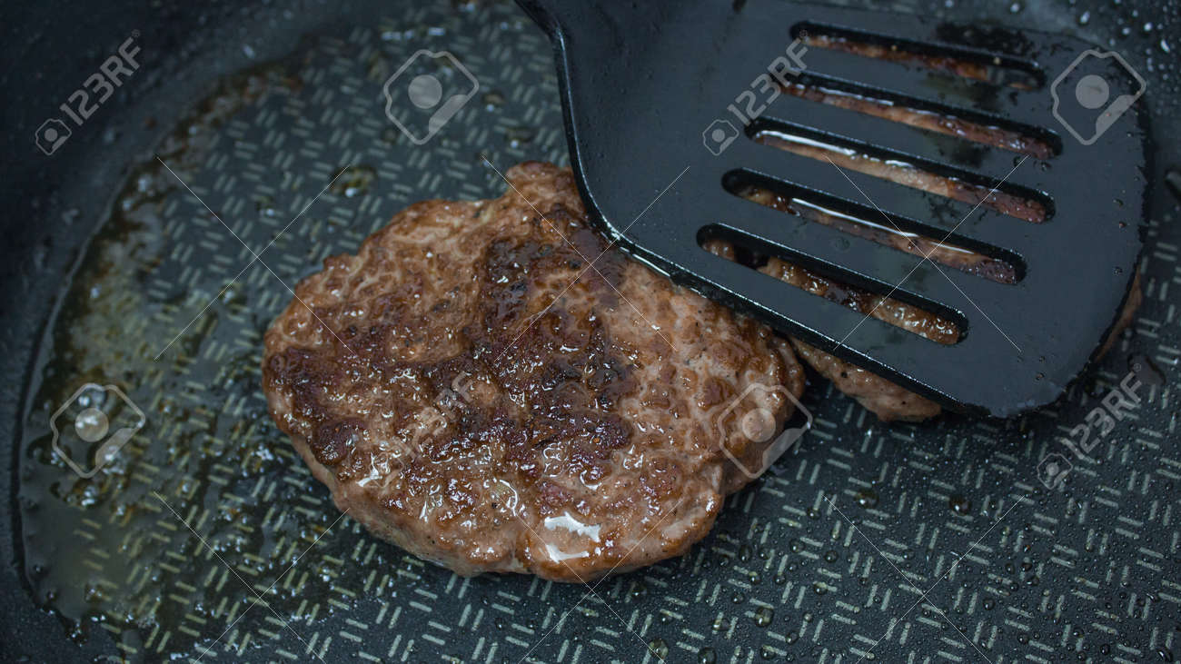 A chef puts beef patties on the grill. A juicy beef cutlet, fried in a pan. Close-up of beef cutlet for a burger on the grill. - 152885195 A chef puts beef patties on the grill. A juicy beef cutlet, fried in a pan. Close-up of beef cutlet for a burger on the grill. - 152885195