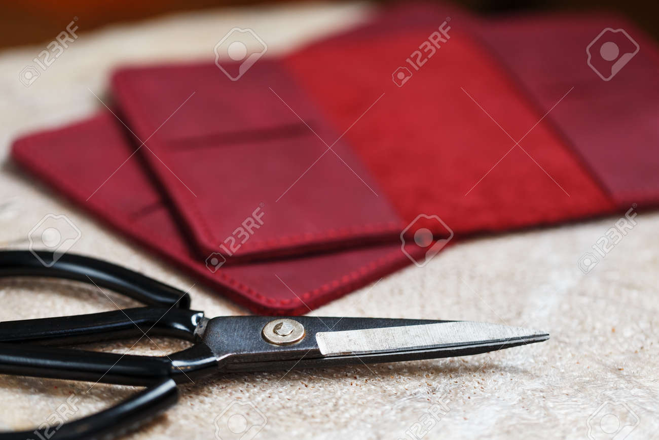 A leather craftsman works with leather. Sews leather goods. Making things handmade. - 142033608 A leather craftsman works with leather. Sews leather goods. Making things handmade. - 142033608