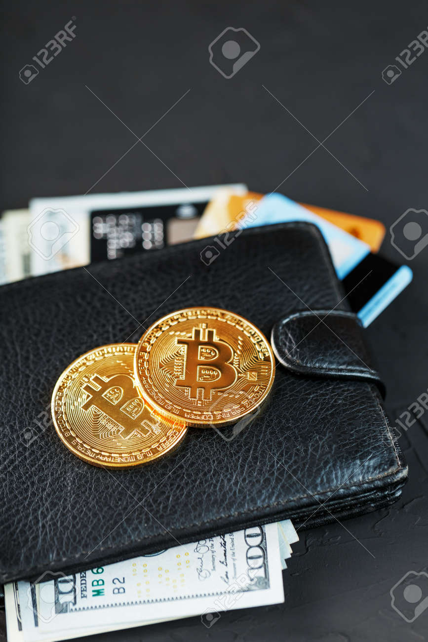 번영과 번영의 상징인 검정색 질감 배경 위에 달러 전자 카드와 비트코인이 있는 검정색 지갑이 닫혀 있습니다. 로열티 무료 사진, 그림,  이미지 그리고 스톡포토그래피. Image 147159129
