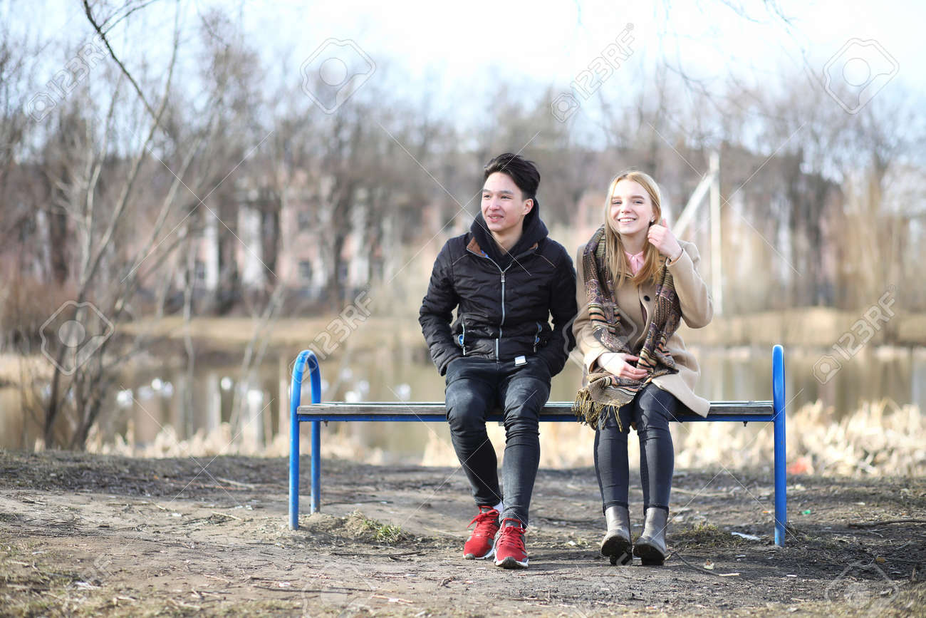 秋の公園のベンチに座っている友人のカップル の写真素材 画像素材 Image