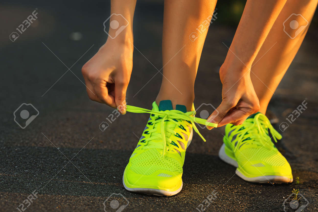 Running shoes. Barefoot running shoes closeup. Female athlete tying laces for jogging on road in minimalistic barefoot running shoes. Runner getting ready for training. Sport lifestyle. - 31878063 Running shoes. Barefoot running shoes closeup. Female athlete tying laces for jogging on road in minimalistic barefoot running shoes. Runner getting ready for training. Sport lifestyle. - 31878063