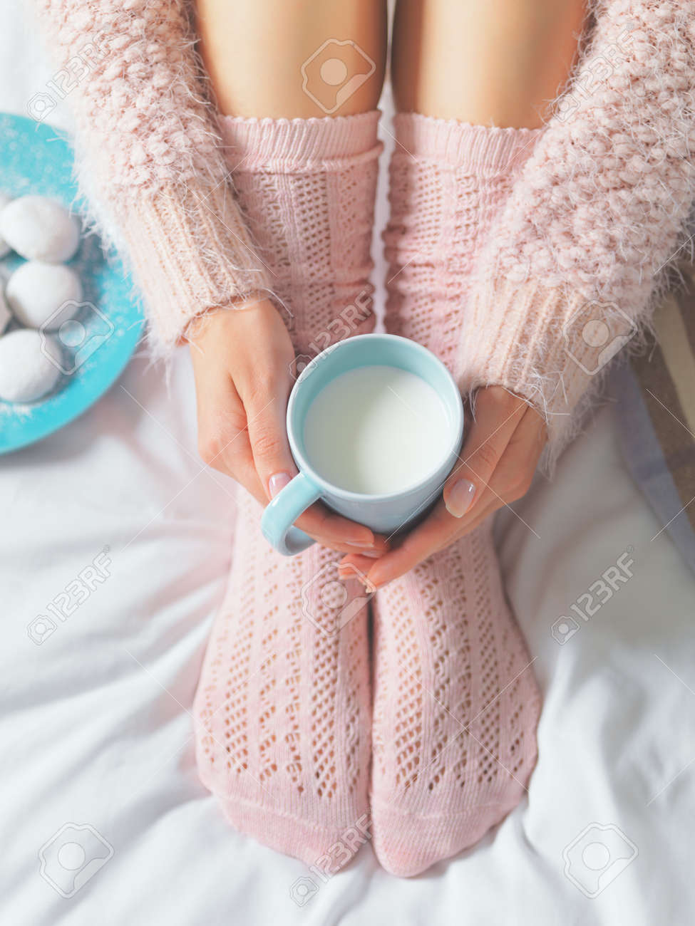 Woman relaxing at cozy home atmosphere on the bed. Young woman with cup of milk in hands and cookies enjoying comfort. Soft light and comfy lifestyle concept. - 41581616 Woman relaxing at cozy home atmosphere on the bed. Young woman with cup of milk in hands and cookies enjoying comfort. Soft light and comfy lifestyle concept. - 41581616