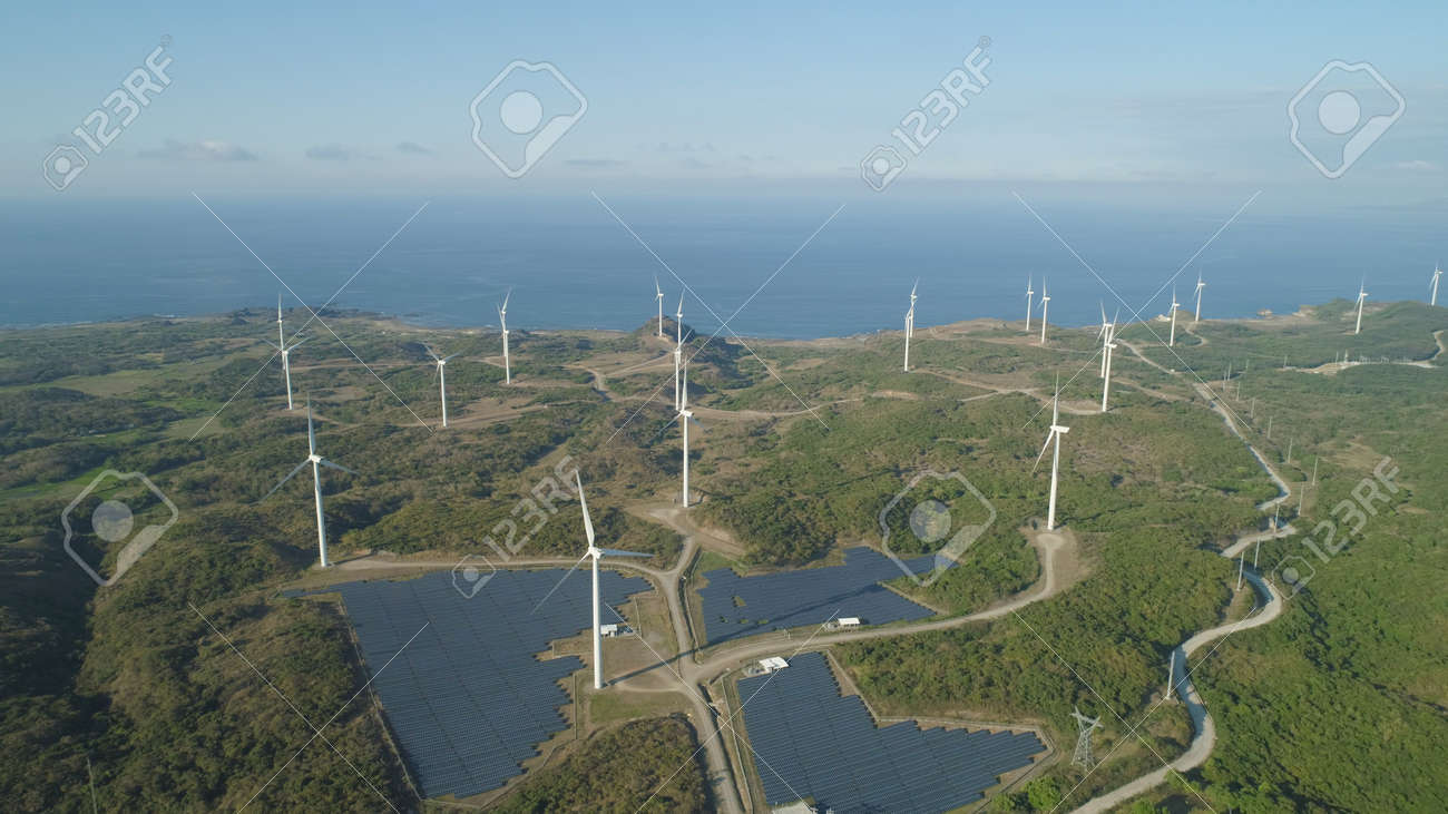Aerial view of Windmills for electric power production on the seashore. Bangui Windmills in Ilocos Norte, Philippines. Solar farm, Solar power station. Ecological landscape: Windmills, sea, mountains. Pagudpud. - 115627367 Aerial view of Windmills for electric power production on the seashore. Bangui Windmills in Ilocos Norte, Philippines. Solar farm, Solar power station. Ecological landscape: Windmills, sea, mountains. Pagudpud. - 115627367