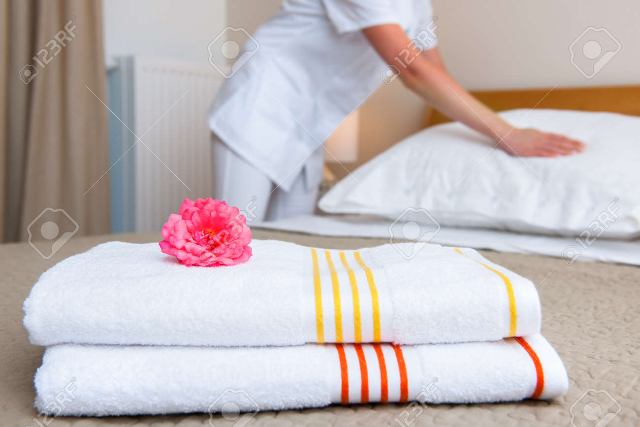 Young maid changing bedclothes in a room - 30796782 Young maid changing bedclothes in a room - 30796782