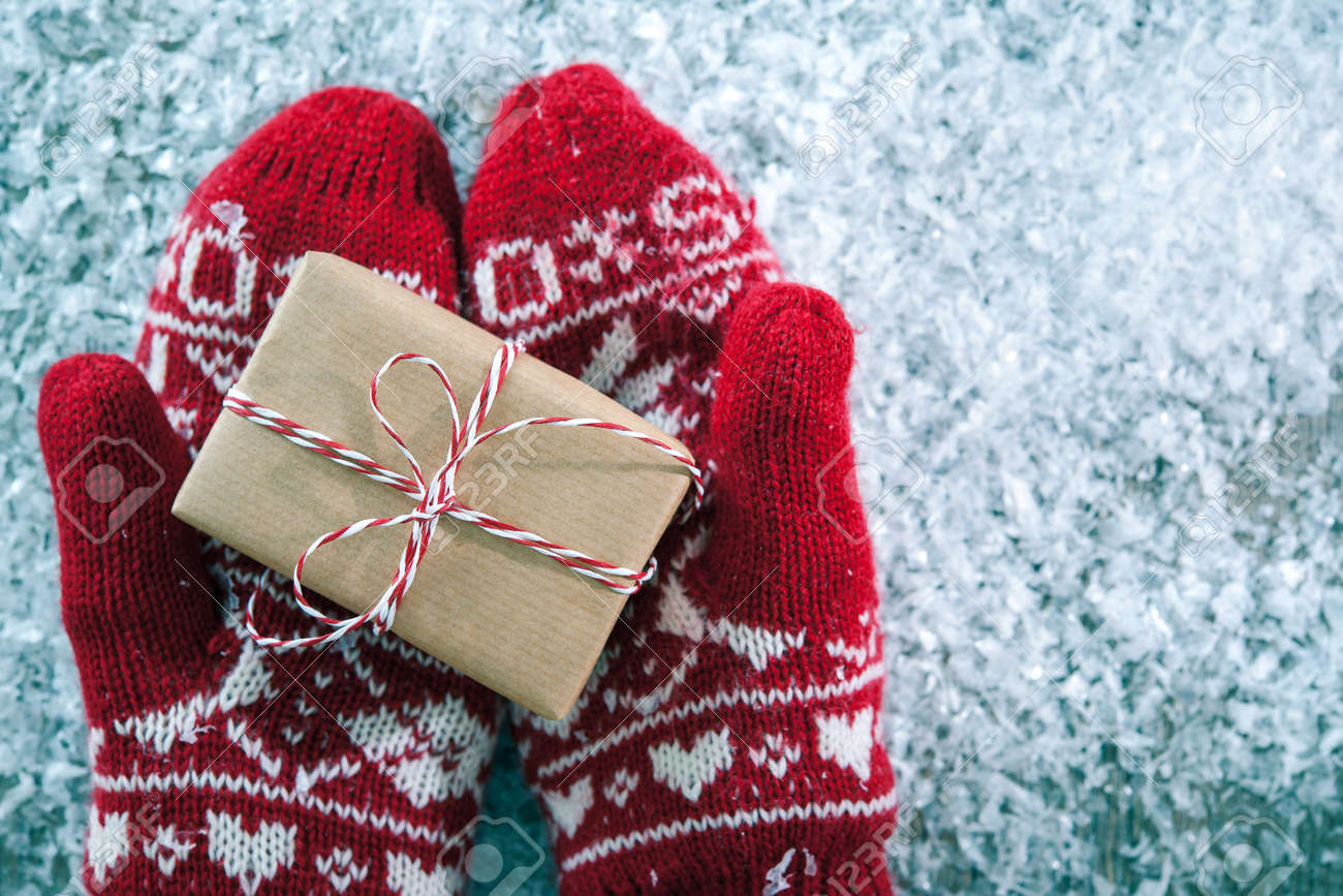 Female hands in winter gloves with christmas gift box - 44129808 Female hands in winter gloves with christmas gift box - 44129808