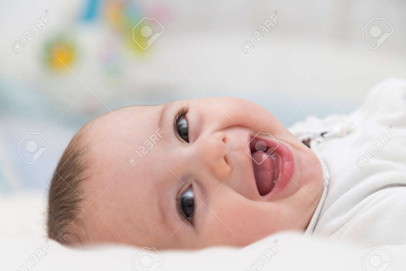 BABY HAPPY. Beautiful and little baby boy happy and smiling resting over the bed. - 155674933 BABY HAPPY. Beautiful and little baby boy happy and smiling resting over the bed. - 155674933