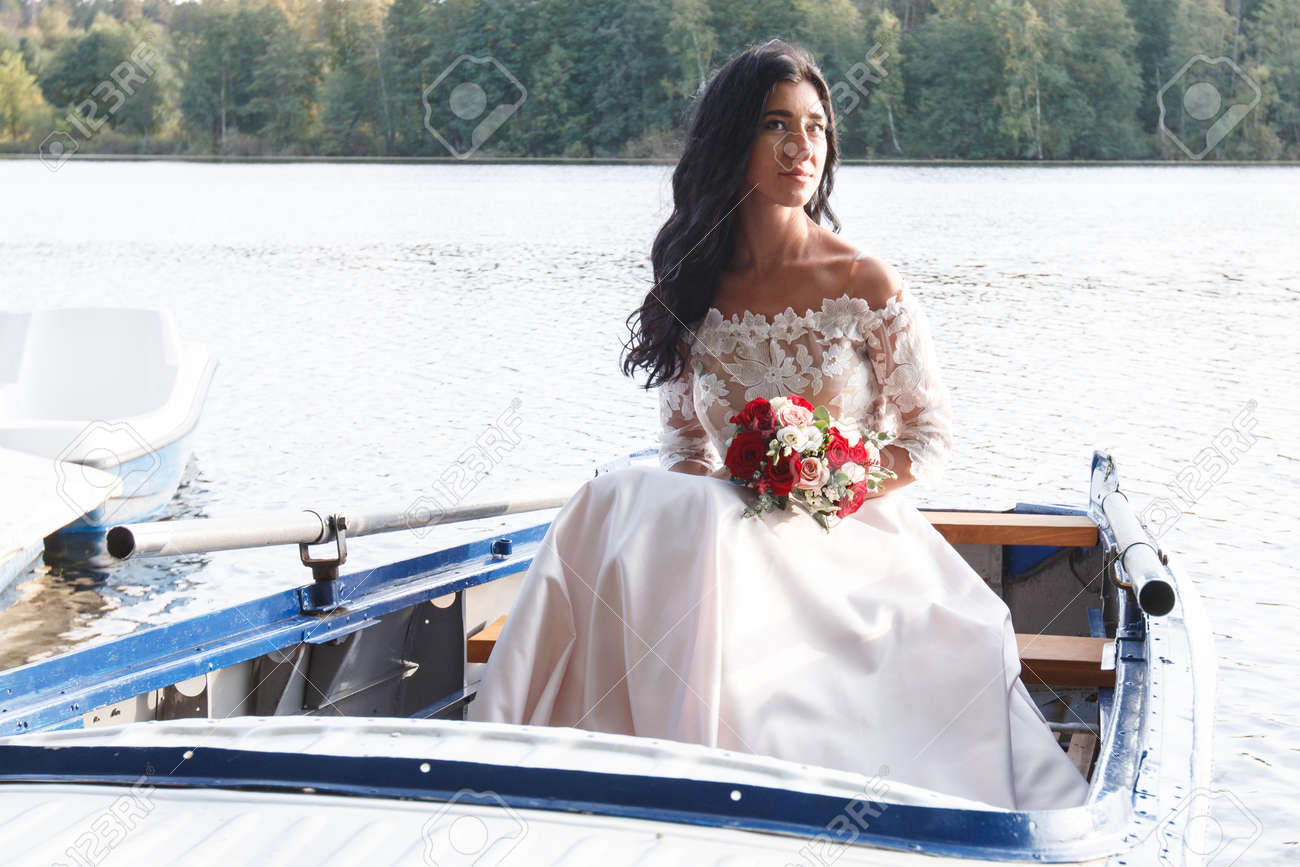 https://previews.123rf.com/images/alexsafronov/alexsafronov1803/alexsafronov180301029/98044326-young-beautiful-russian-bride-with-long-hair-sitting-in-a-boat-and-holding-a-beautiful-wedding-bouqu.jpg