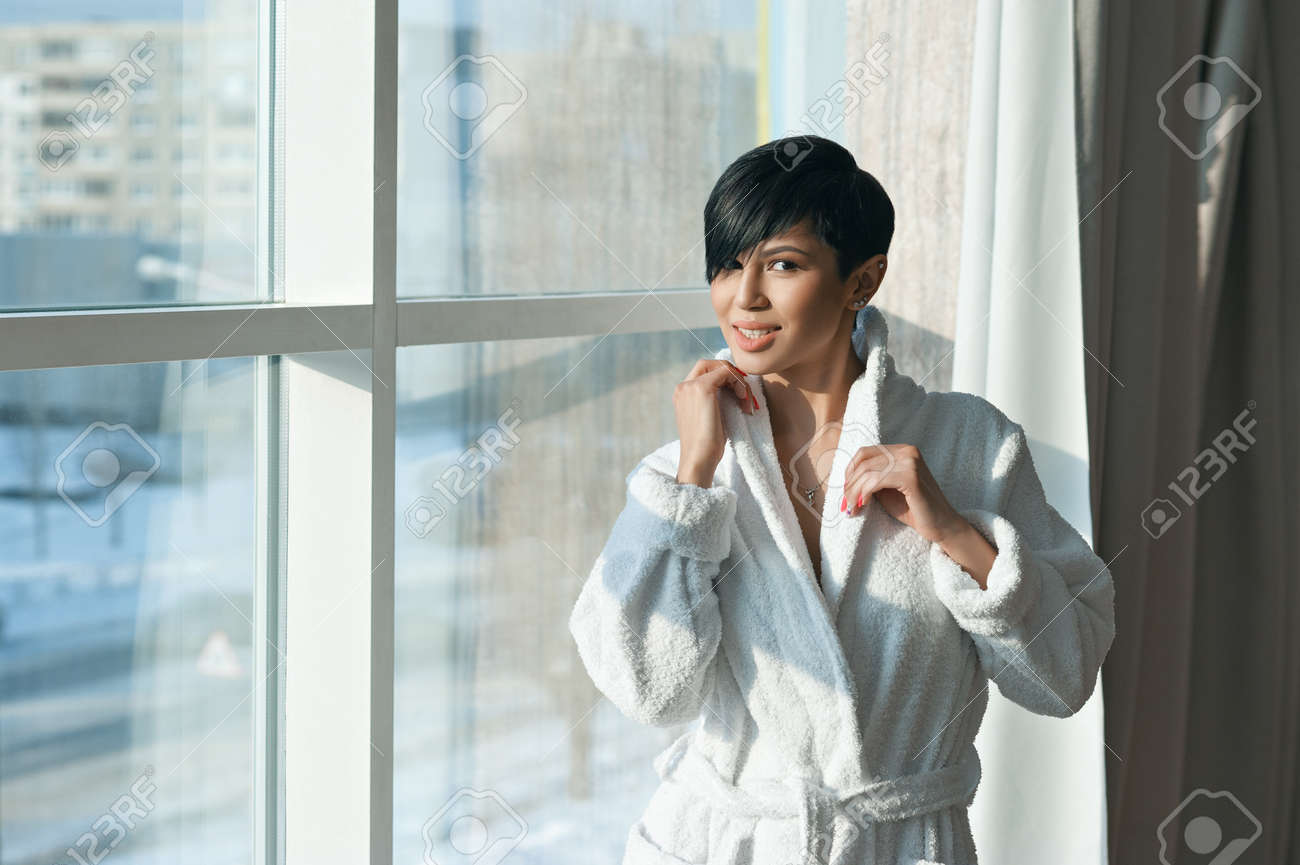 Asian Girl Brunette With A Short Haircut In A White Coat Is