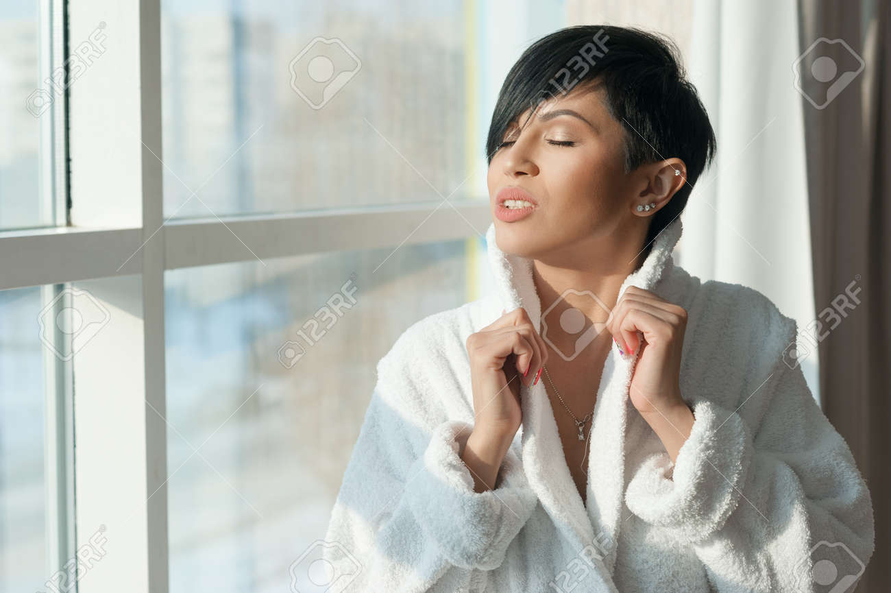 Asian Girl Brunette With A Short Haircut In A White Coat Is
