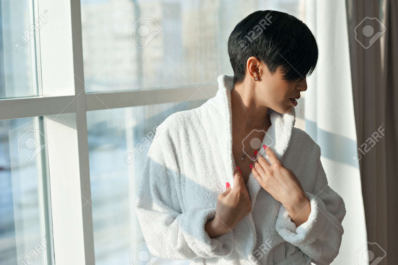Asian Girl Brunette With A Short Haircut In A White Coat Is