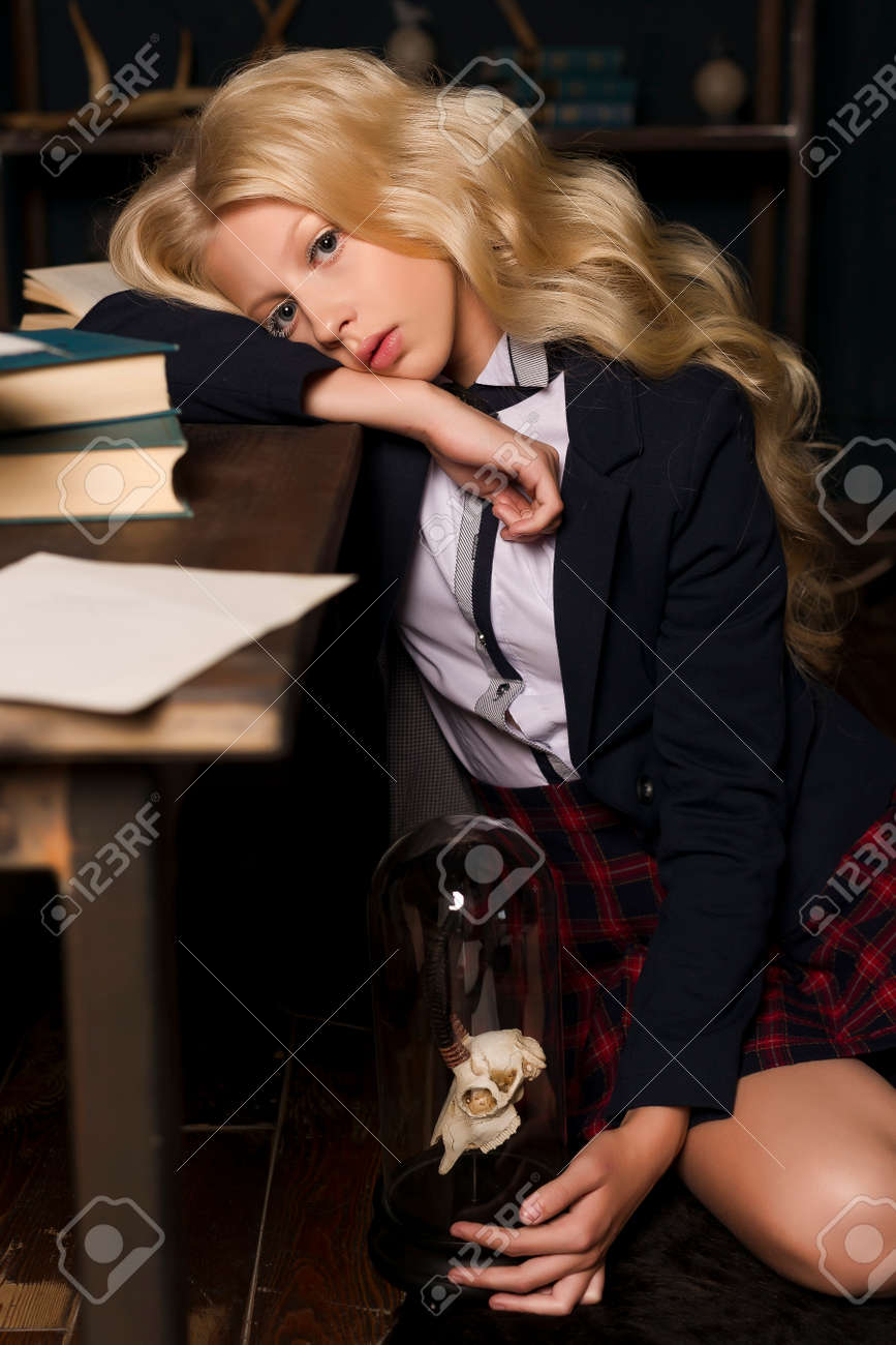 Beautiful Long Haired Blonde Schoolgirl Tiredly Sits On On The Floor At A Table Full Books And Sheets Of Text In A Classic Vintage Interior Room Beautiful Long Haired Blonde Schoolgirl Tiredly Sits On On The Floor At A Table Full Books And Sheets Of Text In A Classic Vintage Interior Room