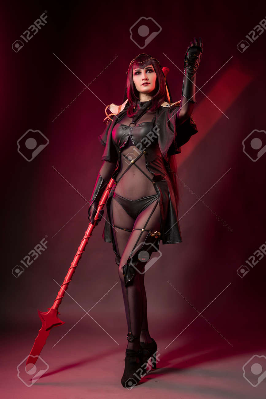 Beautiful Leggy Busty Cosplay Girl Wearing An Erotic Leather Costume Posing  With A Fake Spear On A Red Background In Theatrical Smoke Stock Photo,  Picture and Royalty Free Image. Image 132821690.