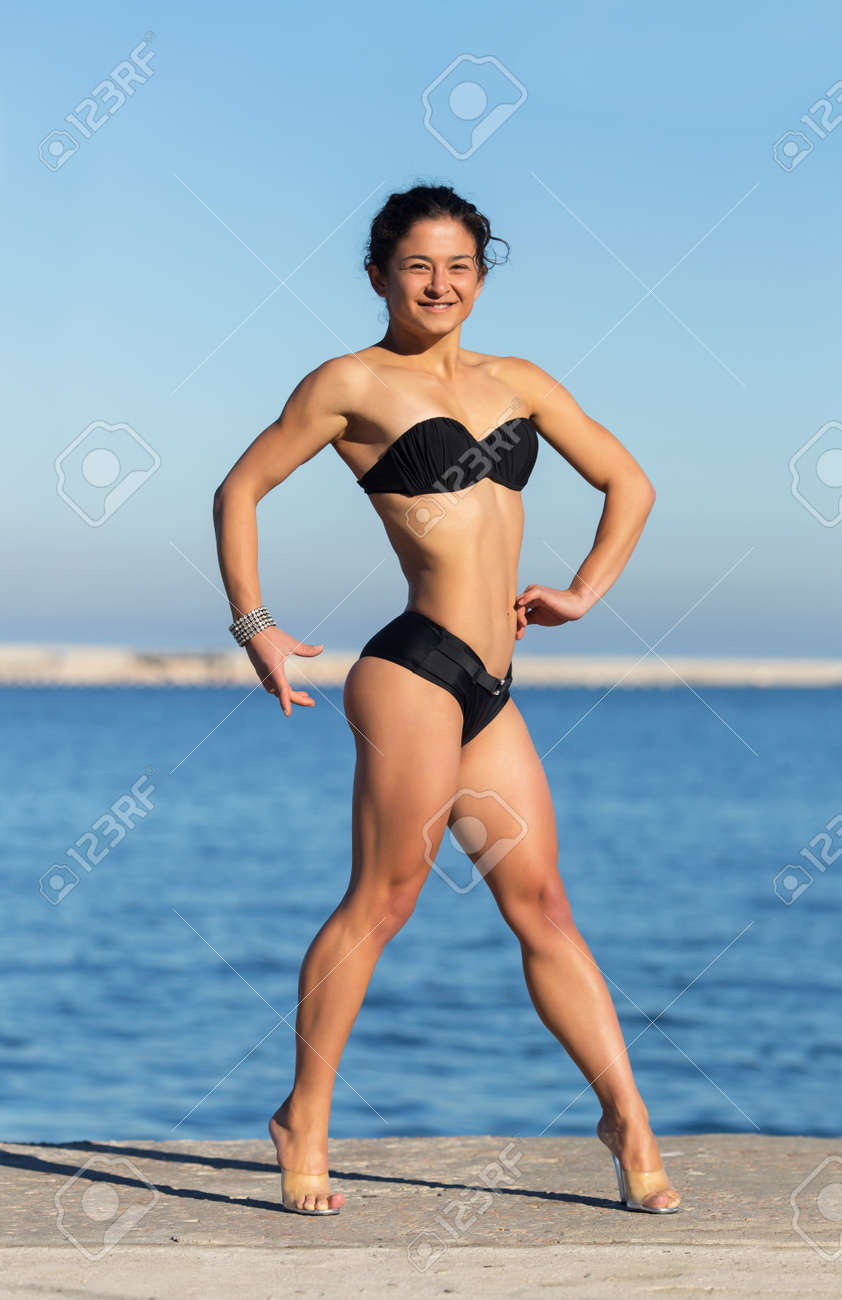 海でアジアの魅力的な女の子 黒い水着でアスリートが海岸に自身の体を示します の写真素材 画像素材 Image 34376881