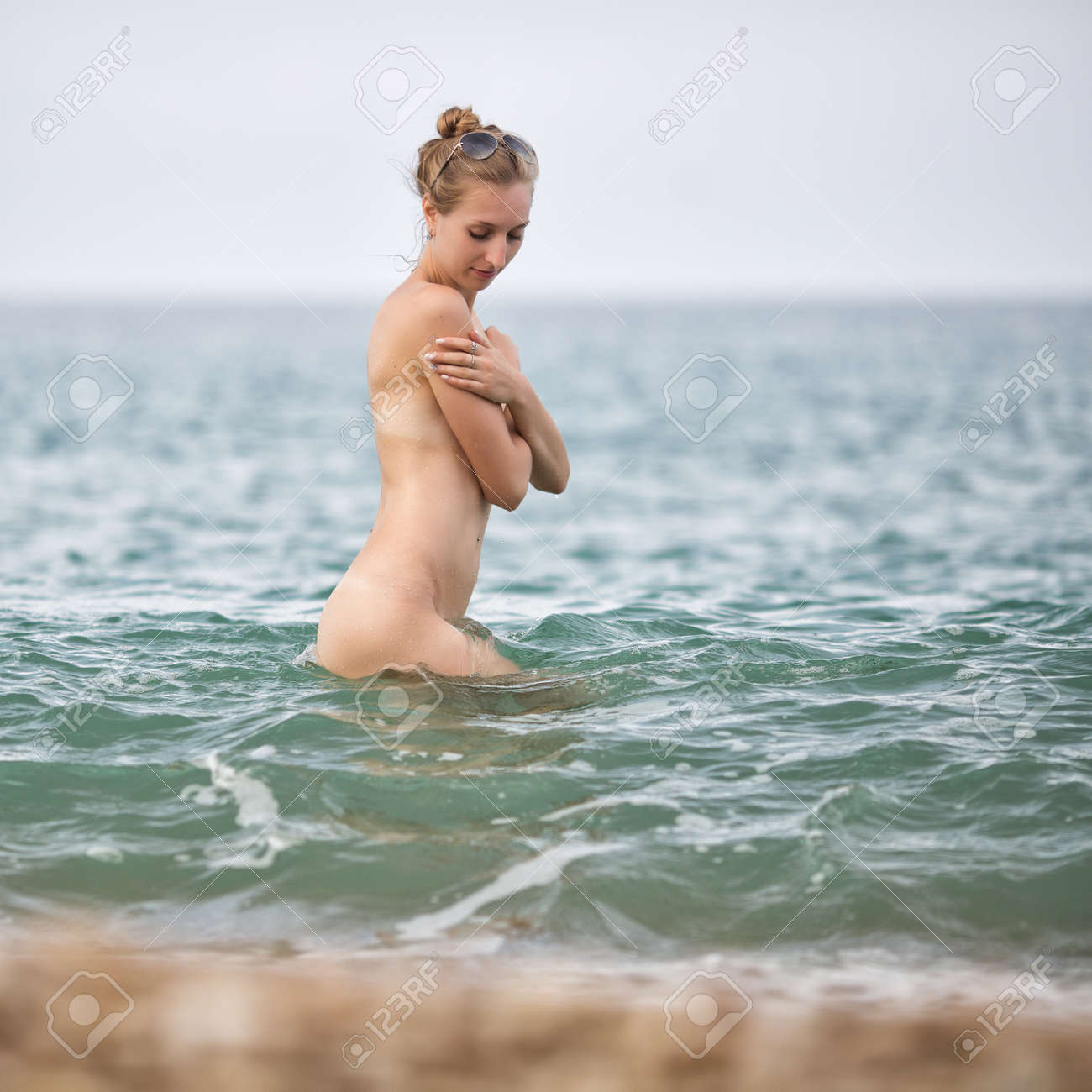 瞑想　女性　全裸 全裸で。裸の若い女性は曇りの日、正方形構成、側面図の彼女の手の下での裸の胸を隠す海で腰を立ち上がるの写真素材・画像素材 Image 72524376