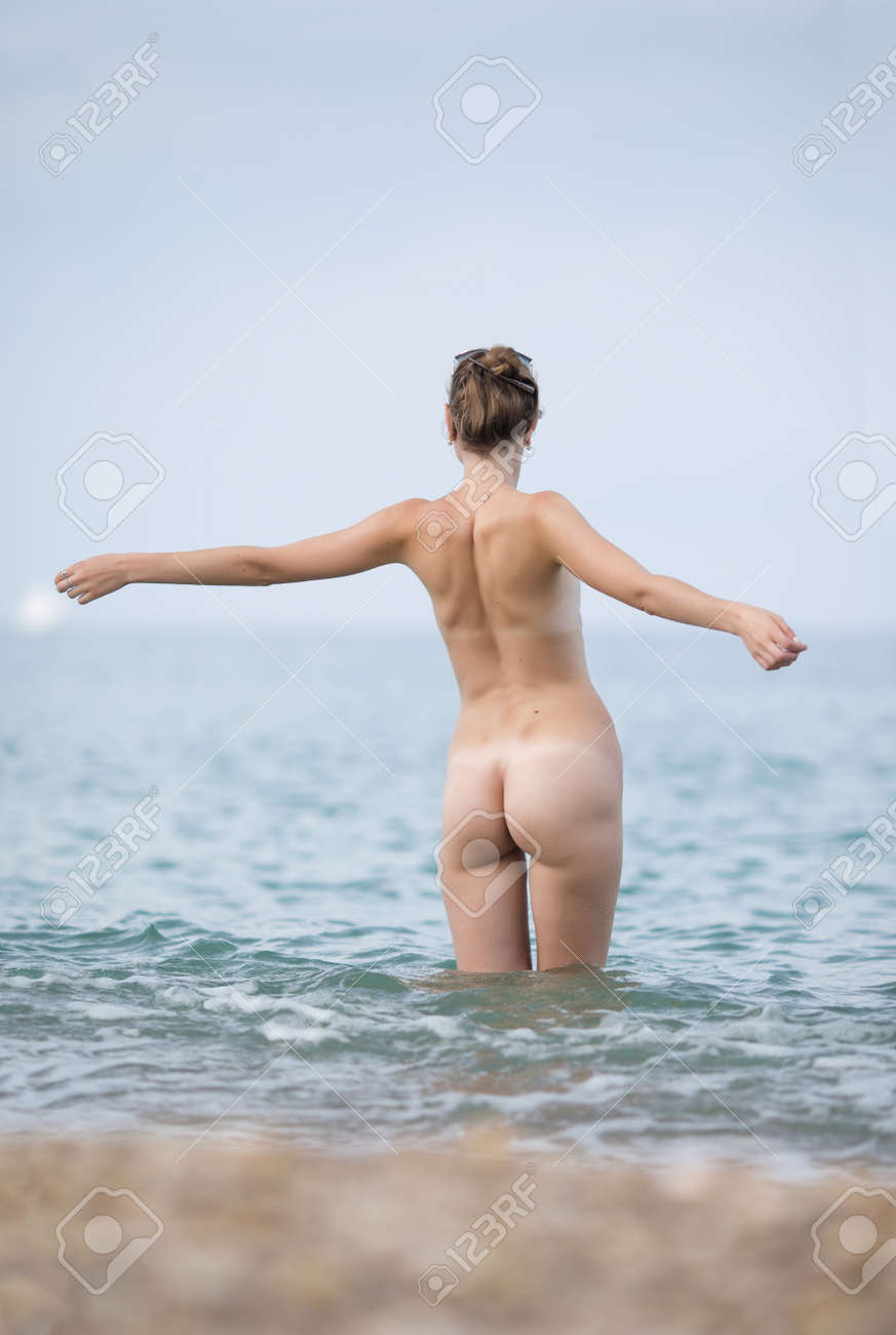 스키니 - 딥. 누드 된 젊은 여자 팔 뻗은 흐린 날, 후면보기에서 바다에 입력 로열티 무료 사진, 그림, 이미지 그리고  스톡포토그래피. Image 72524377