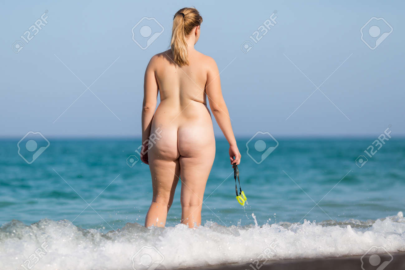Overweight Middle Aged Woman At The Sea. Naked Mature Woman Enters The Sea  Water With Swimming Glasses In Hand, Rear View Stock Photo, Picture and  Royalty Free Image. Image 84373744.