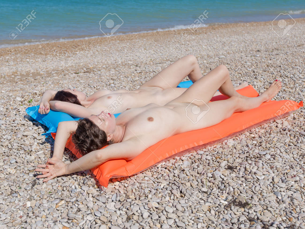 Pareja De Homosexuales En Pebble Beach. Dos Mujeres De 30 Y 40 Años Tomando  El Sol Desnudas Tumbadas En Balsas. Fotos, retratos, imágenes y fotografía  de archivo libres de derecho. Image 94193163