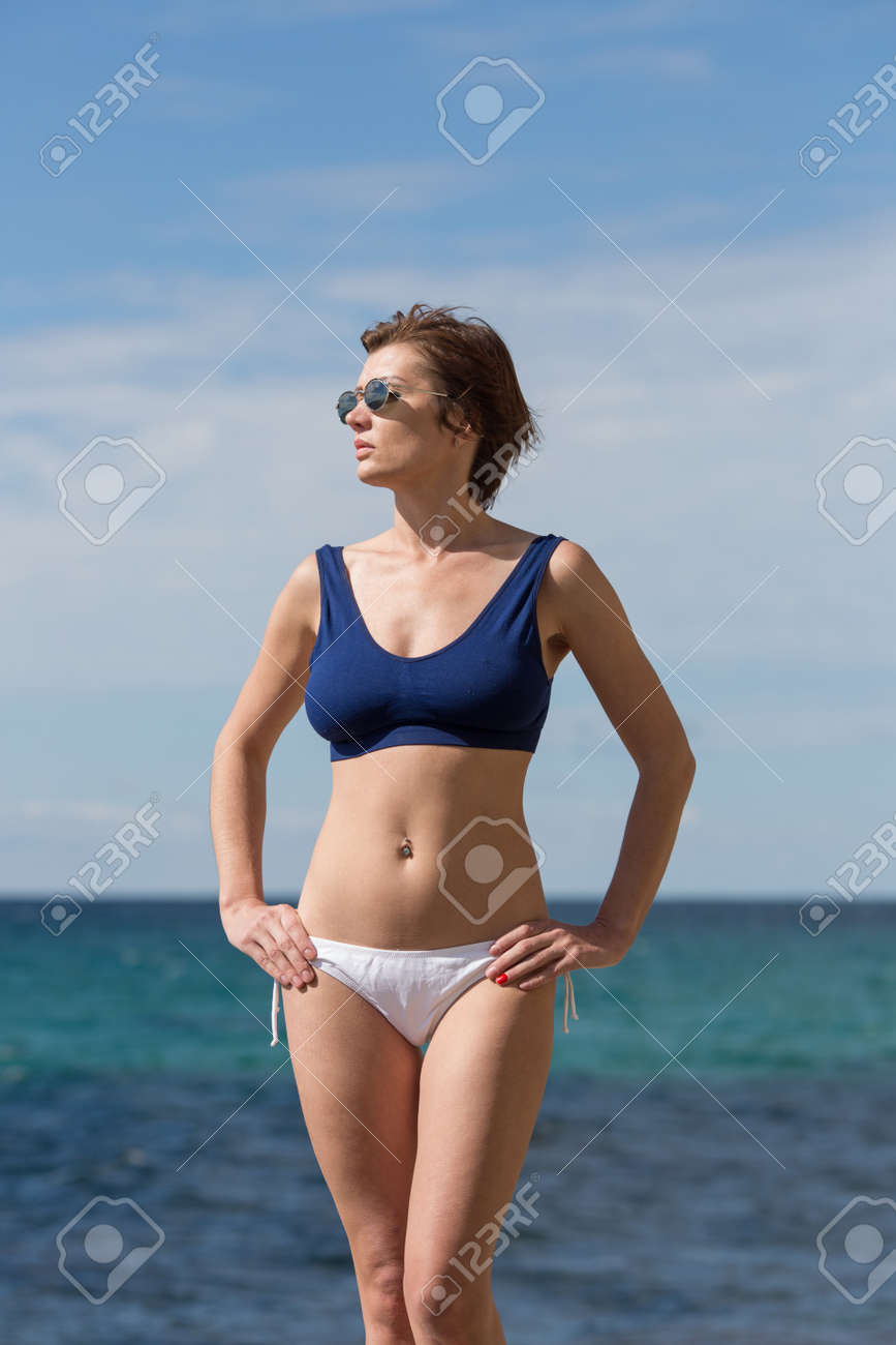Portrait Of Thirty-nine-year-old Woman Against Sea. Female Person In  Sunglasses, Sport Bra And White Panties Posing With Hands On Hips On Beach  Stock Photo, Picture and Royalty Free Image. Image 121342639.