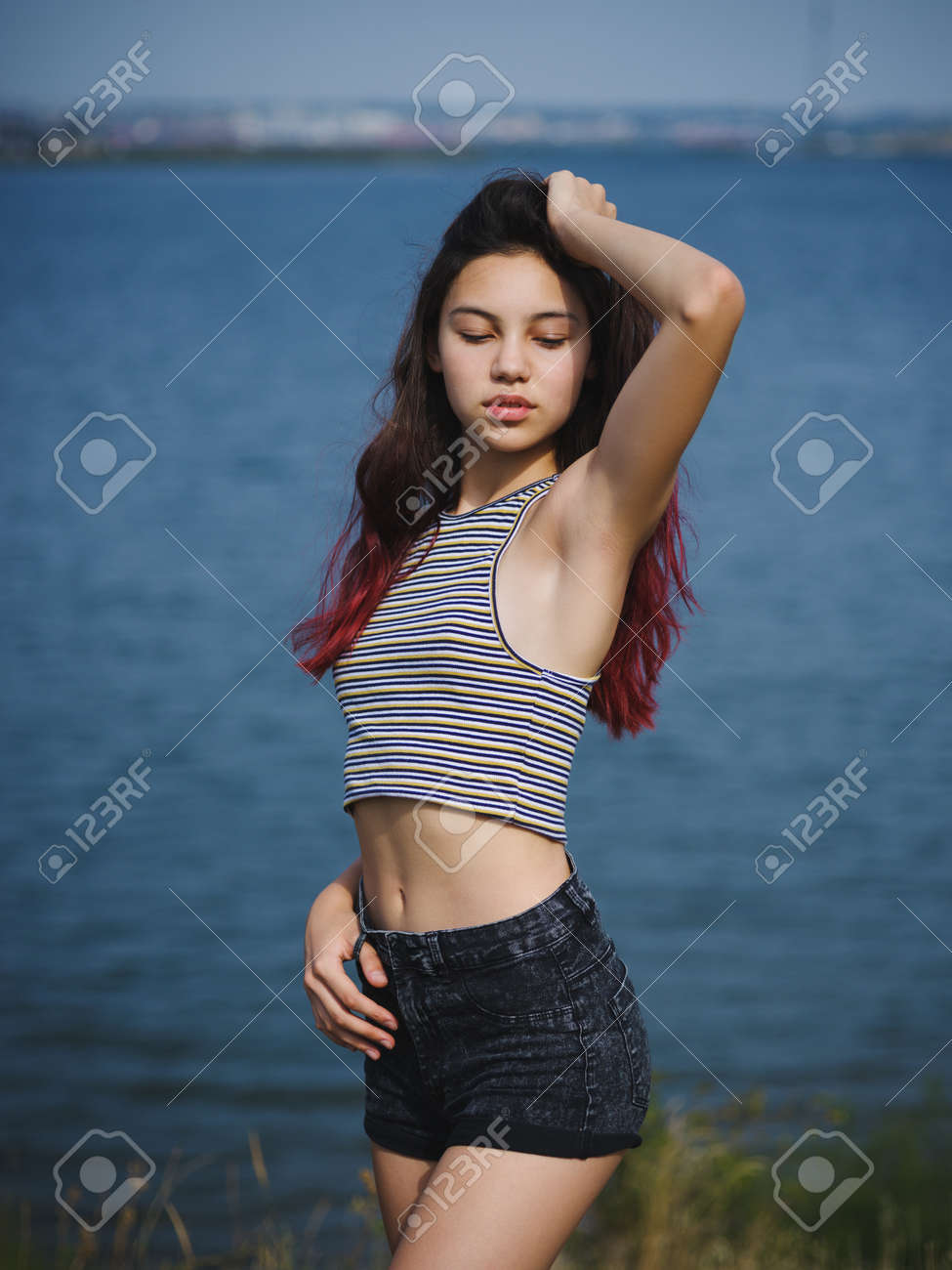 Sexy, Cute Young Girl Touching Her Hair. A Teenager On A Blurred River  Background. Beauty And Style Concept. Copy Space. Stock Photo, Picture And  Royalty Free Image. Image 85253398.