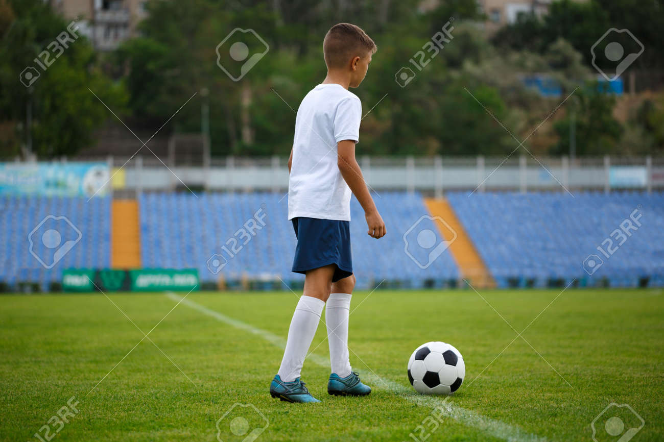 スタジアムの背景に白いスポーティな服を着てかわいいサッカー選手の全長写真 明るい緑の芝生の上の丸いサッカーボール スポーツ 活動 健康と人の概念 の写真素材 画像素材 Image スタジアムの背景に白いスポーティな服を着てかわいいサッカー選手の全長写真 明るい緑の芝生の上の丸いサッカーボール スポーツ 活動 健康と人の概念 の写真素材 画像素材 Image