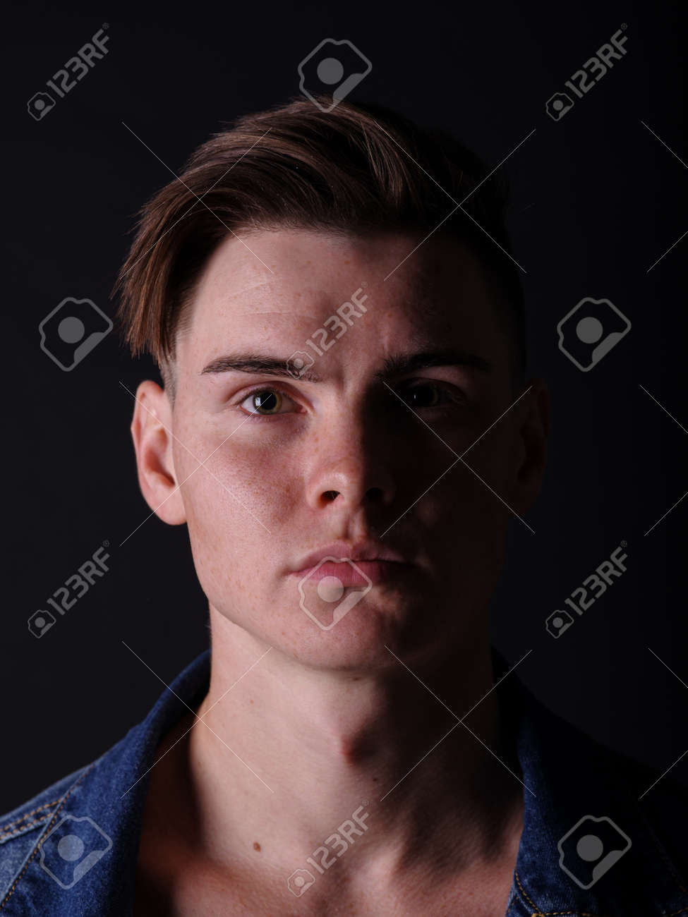 Close Up Pretty Teenage Boy In A Jeans Jacket On A Black Background