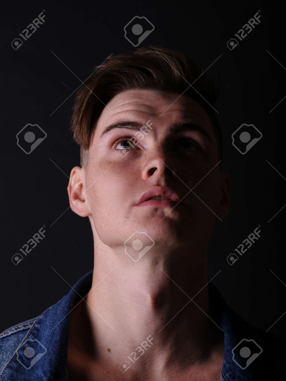 Close Up Pretty Teenage Boy In A Jeans Jacket On A Black Background