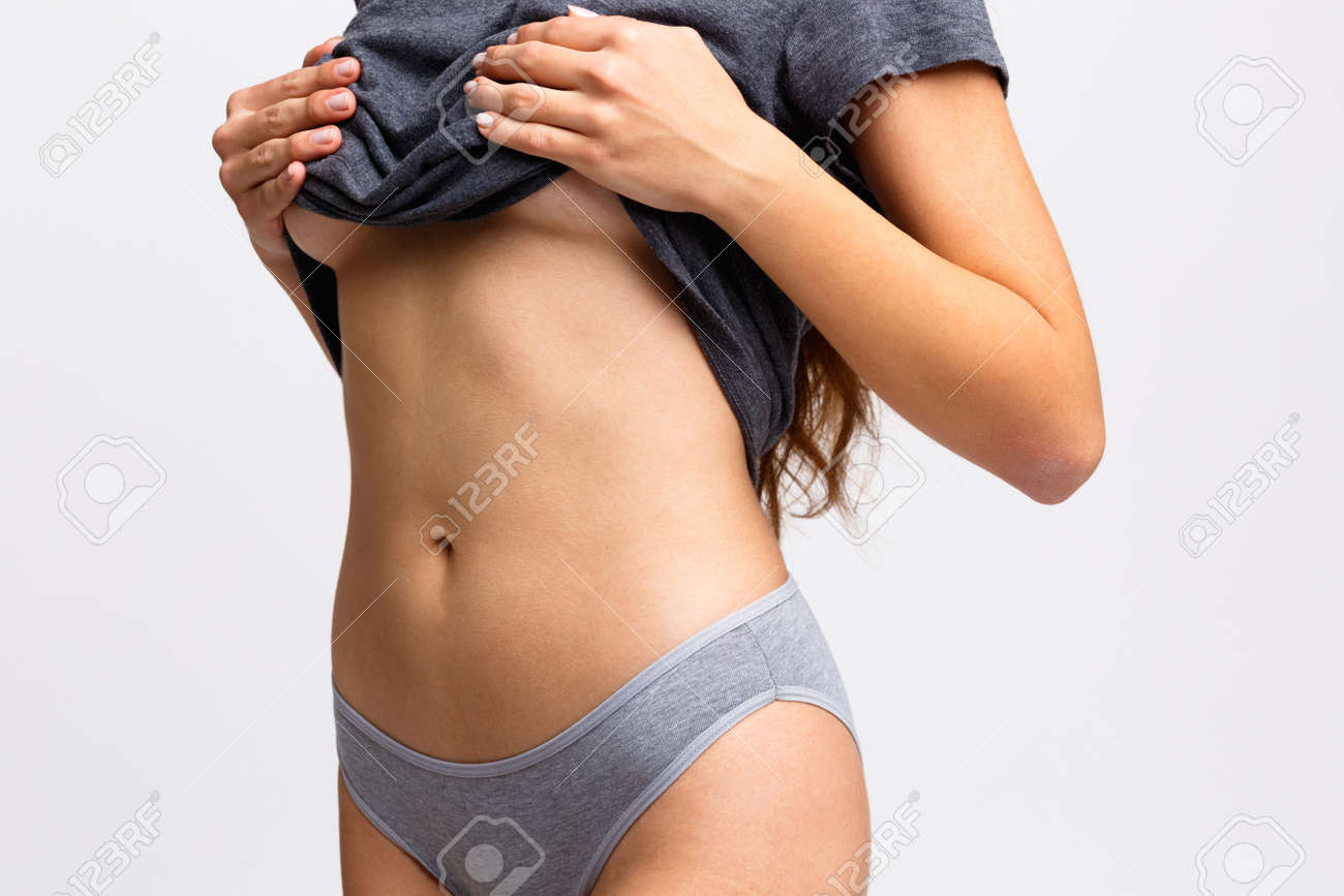 セクシーな彼女の胸に彼女のタンクトップを上げ 灰色の背景に腹をクローズアップ の写真素材 画像素材 Image セクシーな彼女の胸に彼女のタンクトップを上げ 灰色の背景に腹をクローズアップ の写真素材 画像素材 Image