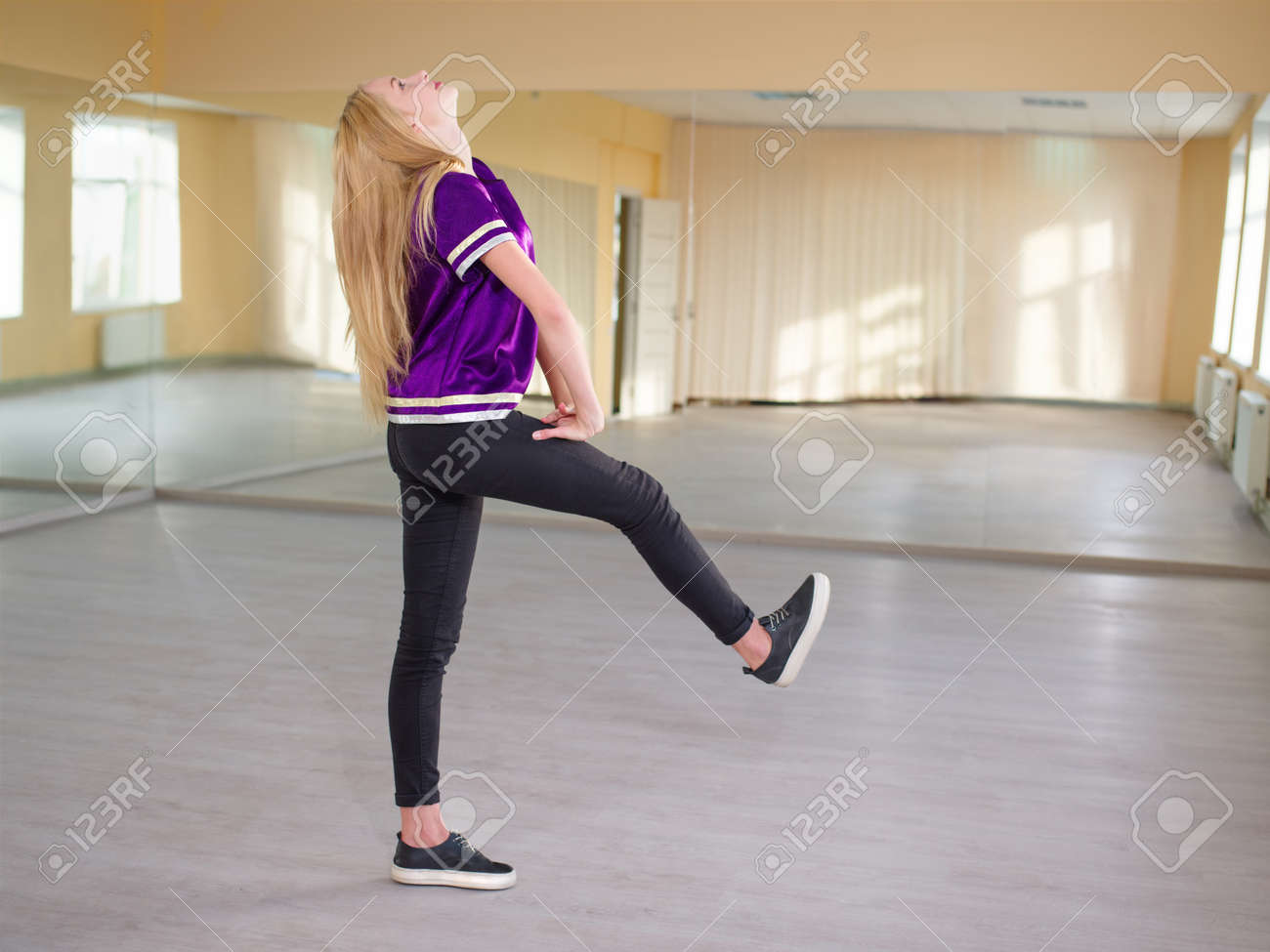 かわいい女の子 ブロンド ダンス 彼女の足を前方に置く ライトダンススタジオでポーズ の写真素材 画像素材 Image