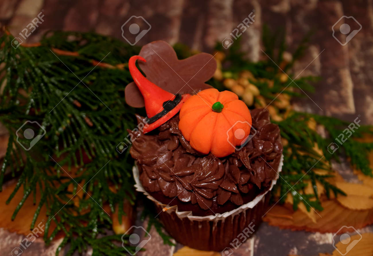 はがきカボチャと帽子 焼くとハロウィーンの装飾のためのアイデア チョコレート ケーキは 砂糖帽子 カボチャ オレンジとチョコレートの男で飾られて それは 石の壁 秋の黄葉 Thuja の緑の枝を模倣に値するです 招待状 グリーティング カードやデスクトップ上の