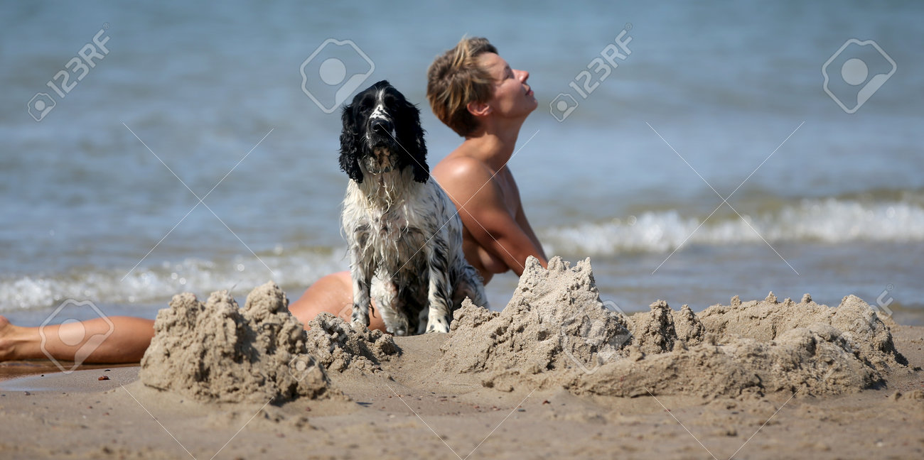 ヌディストビーチ 女性の姿と犬、ヌーディストビーチの夏のシーンの写真素材・画像素材 Image 201189612