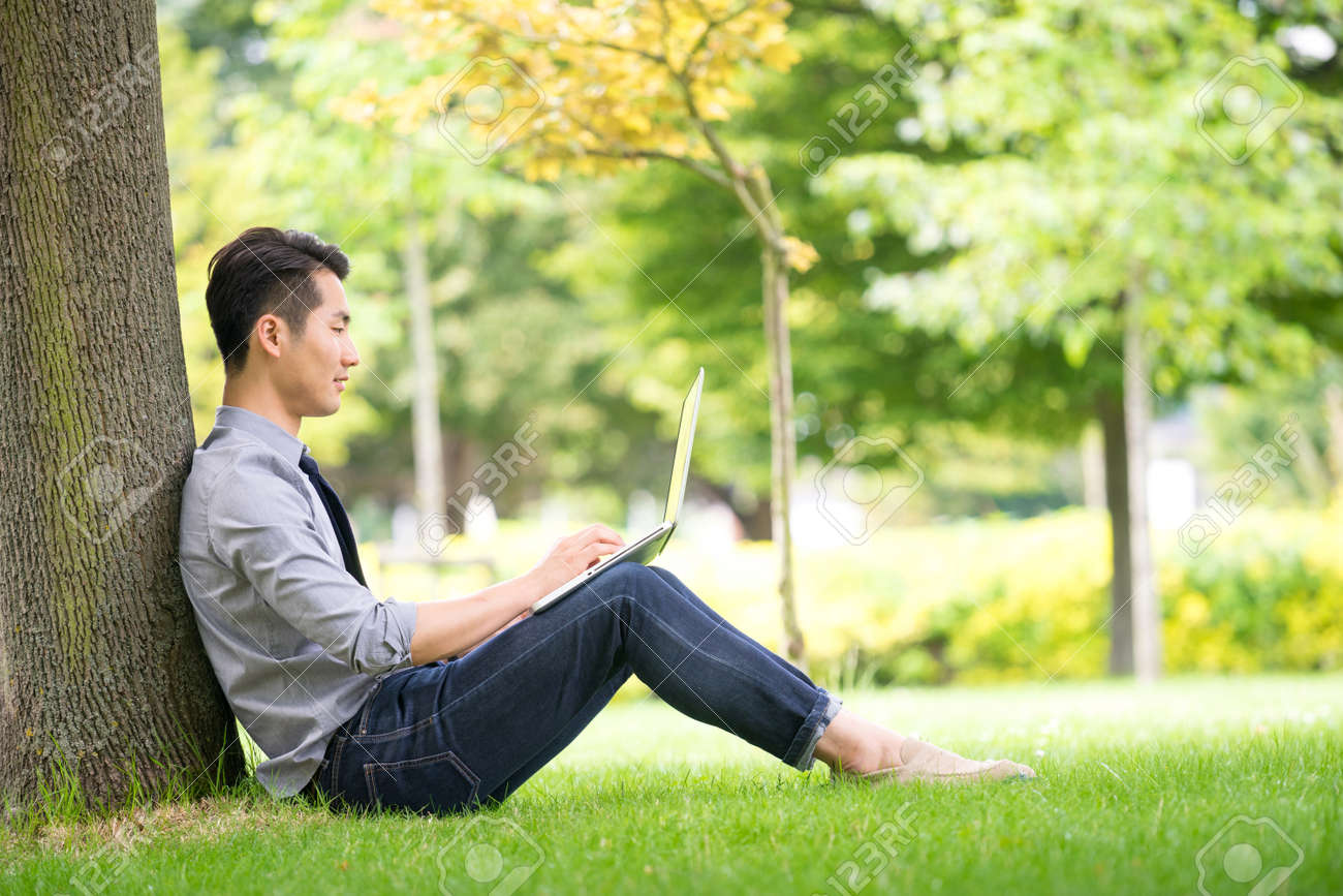 Young asian & success businessman using tablet, laptop, mobile phone in the park - 44147925 Young asian & success businessman using tablet, laptop, mobile phone in the park - 44147925