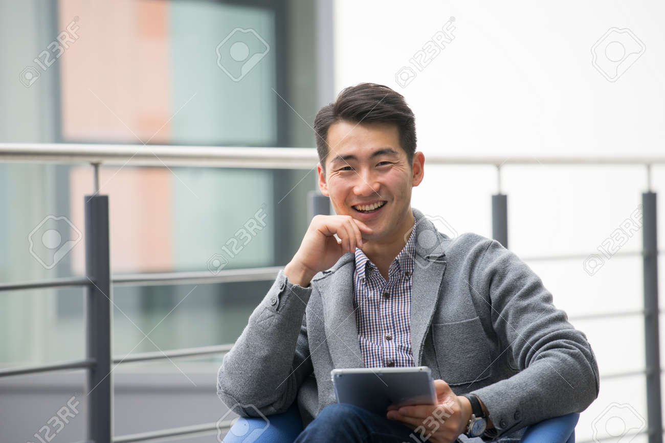 Young asian businessman using tablet, mobile phone in the office - 44437963 Young asian businessman using tablet, mobile phone in the office - 44437963