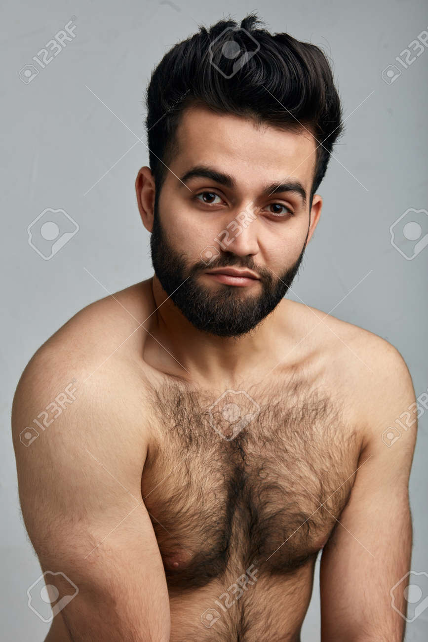 Attractive Young Weak Indian Guy With Hairy Body . Close Up Photo. Man  Doesnt Keep Fit. Isolated Gray Background Фотография, картинки, изображения  и сток-фотография без роялти. Image 122125453
