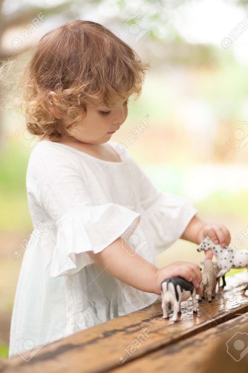 ファーム動物フィギュア屋外で遊ぶかわいい幼児の女の子 夏のレジャー 子供の頃の田舎で 子供の農場の動物を学習します 早期教育と開発 の写真素材 画像素材 Image