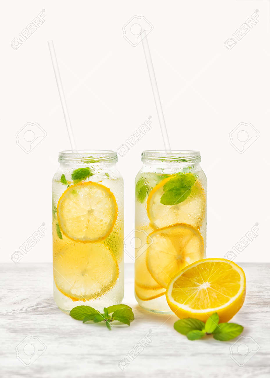 新鮮なレモンと自家製レモネードと明るい背景にストローで小枝ミントをクローズ アップ の写真素材 画像素材 Image
