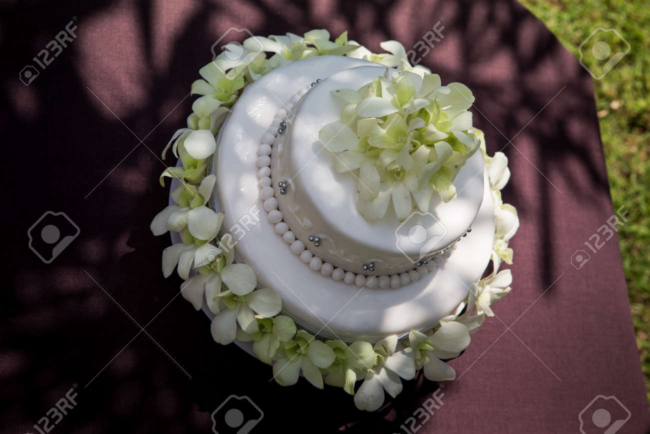 View Of Large White Wedding Cake With White Orchids And Pearls