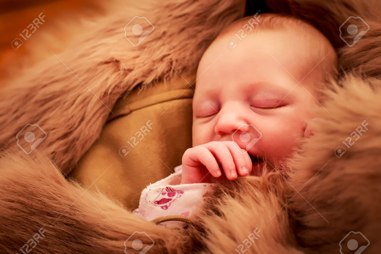 寝顔と茶色の羊だらけの指をしゃぶり 生まれたばかりの赤ちゃんのポートレート クローズ アップ の写真素材 画像素材 Image