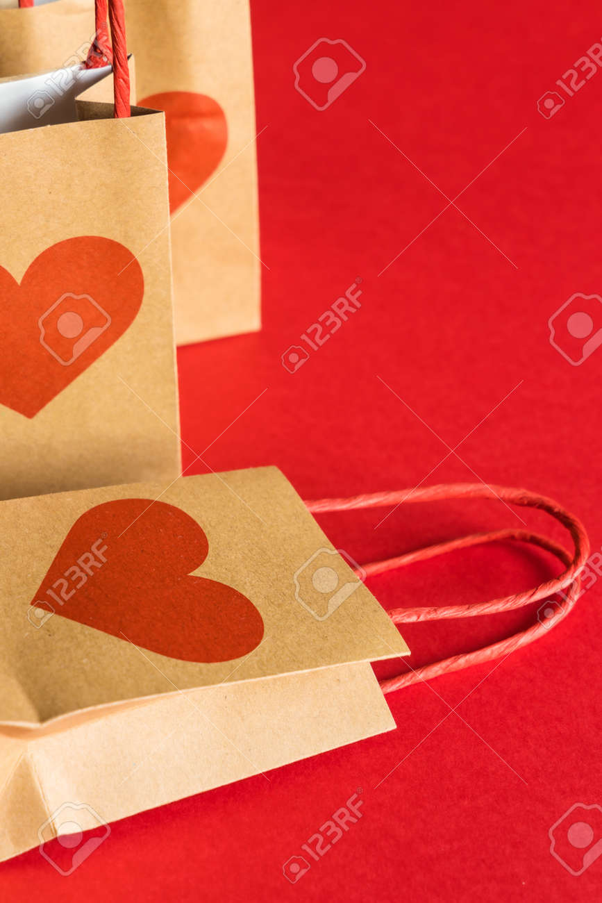 Valentines Day concept. Shopping paper bags with hearts print on red background. - 158366398 Valentines Day concept. Shopping paper bags with hearts print on red background. - 158366398