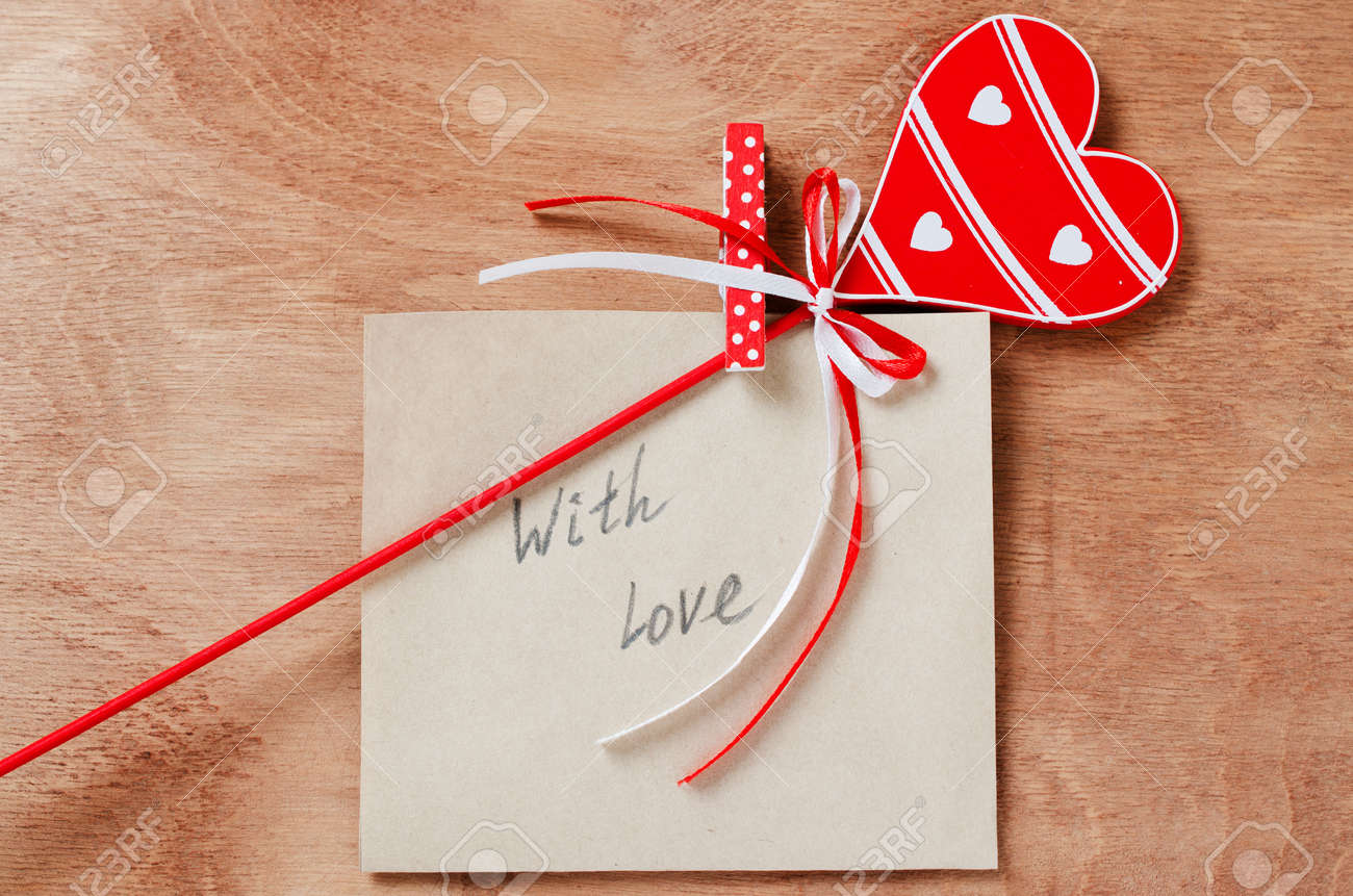 バレンタインデーで木製のテーブルに手紙と木製の赤いハートに愛をこめてメッセージ カード 上からの眺め の写真素材 画像素材 Image