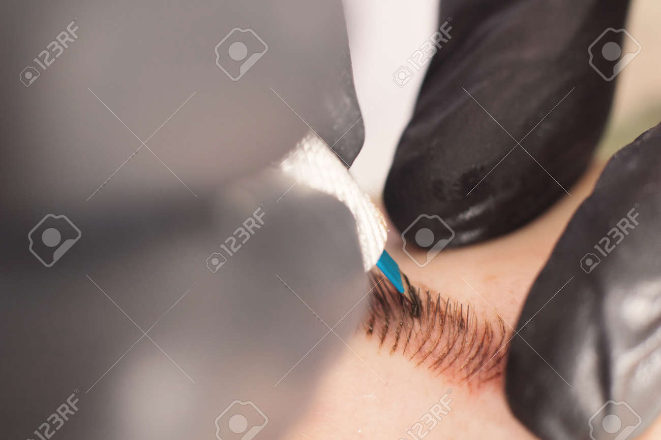 Cosmetologist applying permanent make up on eyebrows. Permanent tattooing of eyebrows. - 76092985 Cosmetologist applying permanent make up on eyebrows. Permanent tattooing of eyebrows. - 76092985