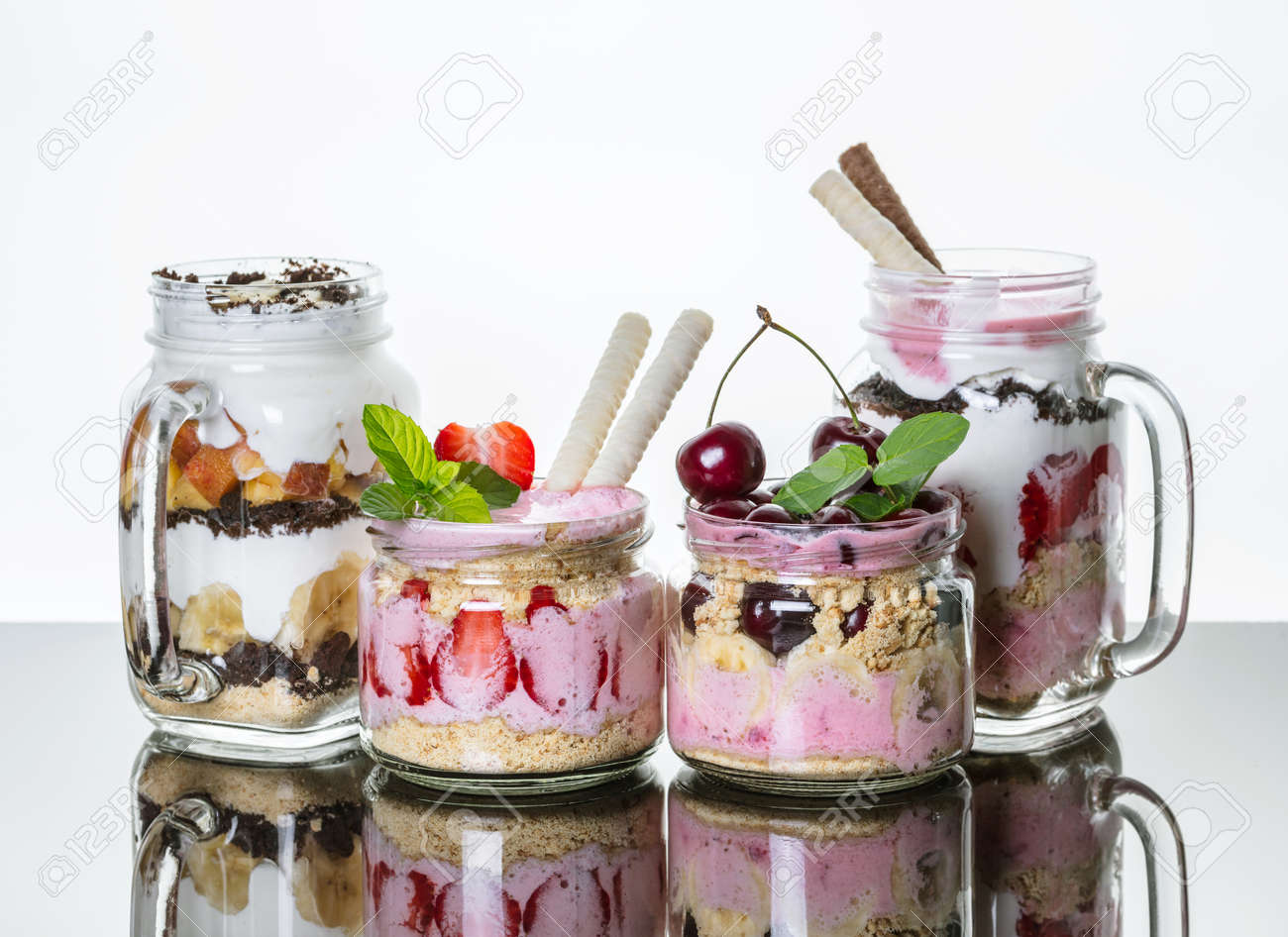 fruit desserts in a jar with reflection on light background stock
