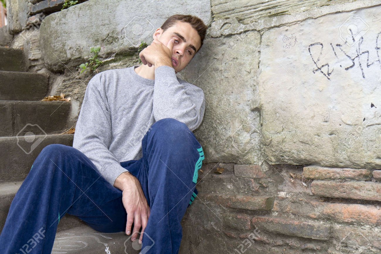 Retrato De Un Hombre Sin Hogar Con Problemas De Mal Sentado Contra