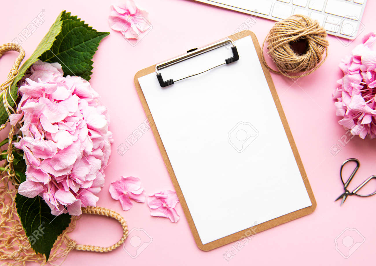 Beauty composition with clipboard, hydrangea and accessory on pink background. Top view. Flat lay. Home feminine desk. - 138827078 Beauty composition with clipboard, hydrangea and accessory on pink background. Top view. Flat lay. Home feminine desk. - 138827078