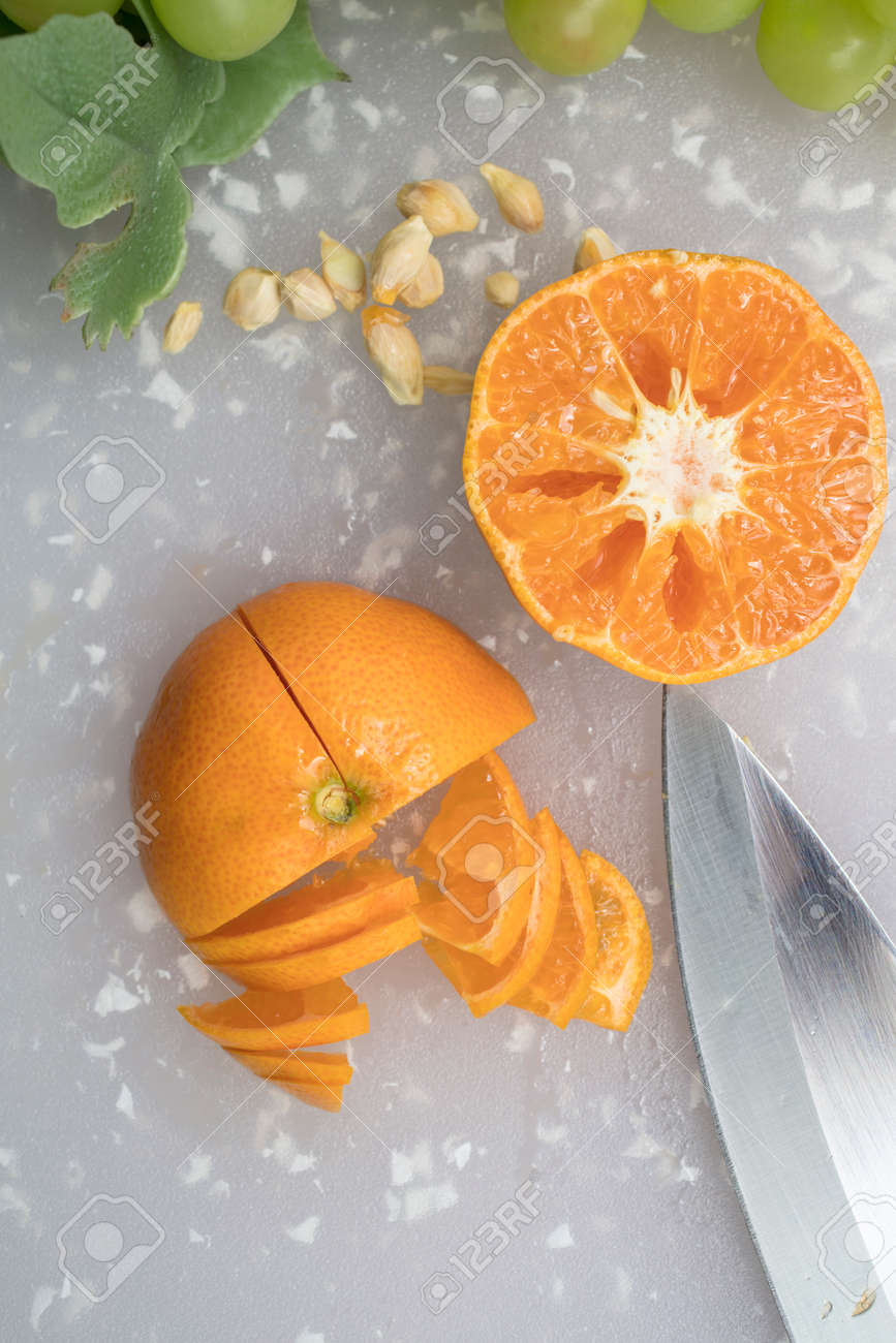 みかんは ブドウ 種子 ナイフでまな板の上にスライスされています の写真素材 画像素材 Image