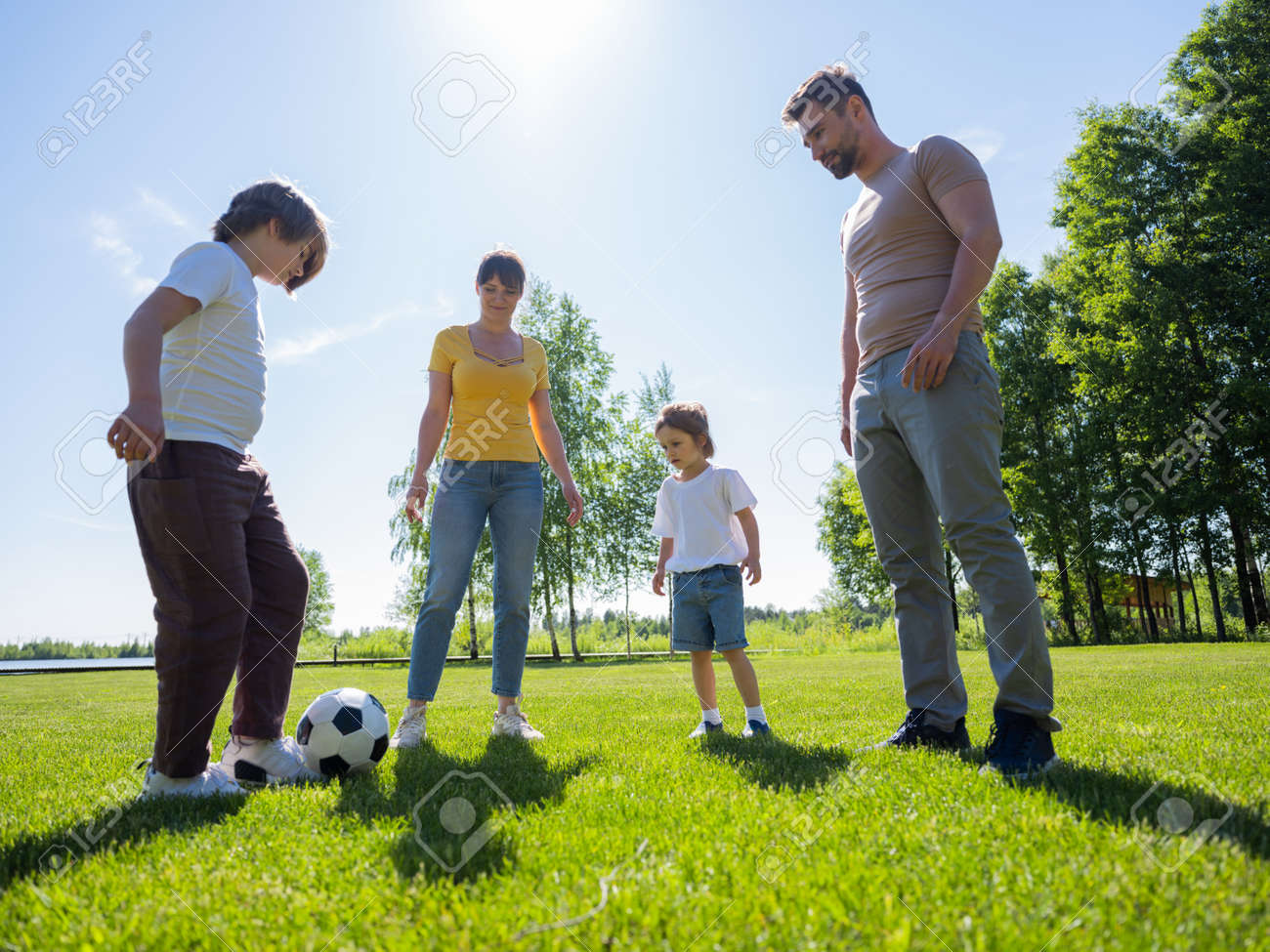 Happy family with two children play soccer in their leisure time - 190212287